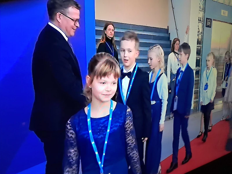 Kuvankaappaus Yle Areenasta: Alisa edessä sinisessä mekossa, Leevi Alisan takana.