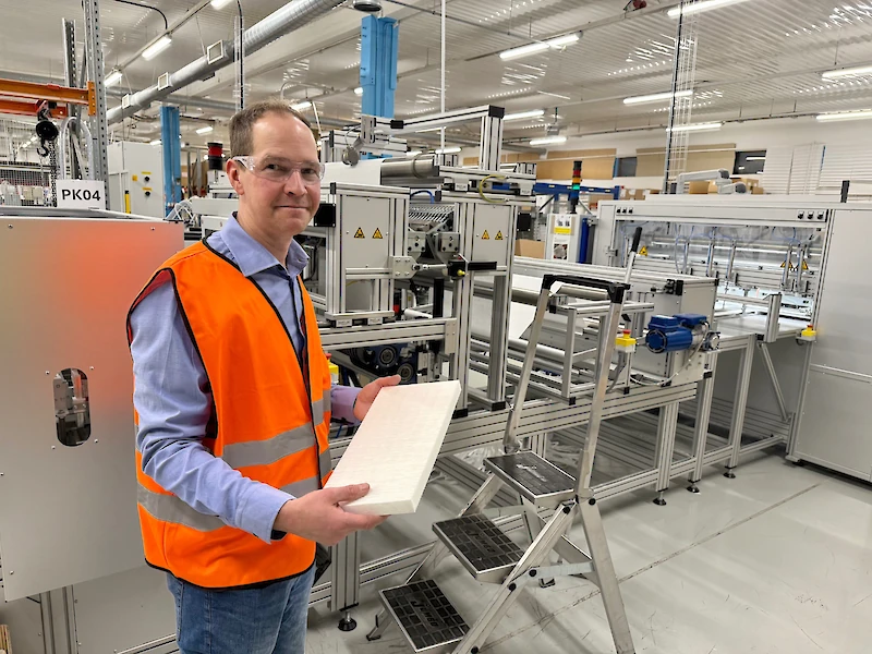 Kausalan tehtaan tehdaspäällikkö Veli-Pekka Martikainen pitelee liimauskoneesta tullutta paperisuodatinta.