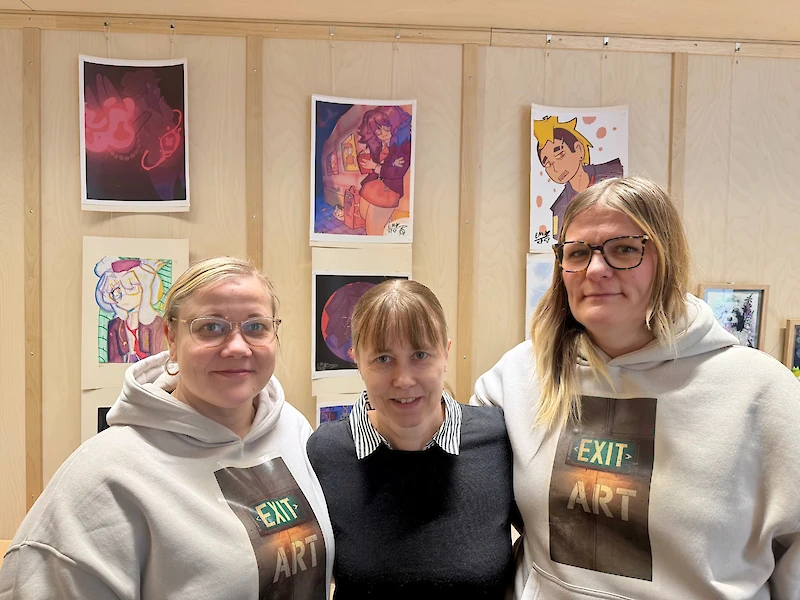 Maikki Riihimäki, Irina Barkman ja Satu Halonen kuvattuna kirjaston Sjögren-salissa, jota koristaa iittiläisten nuorten kuvataide.