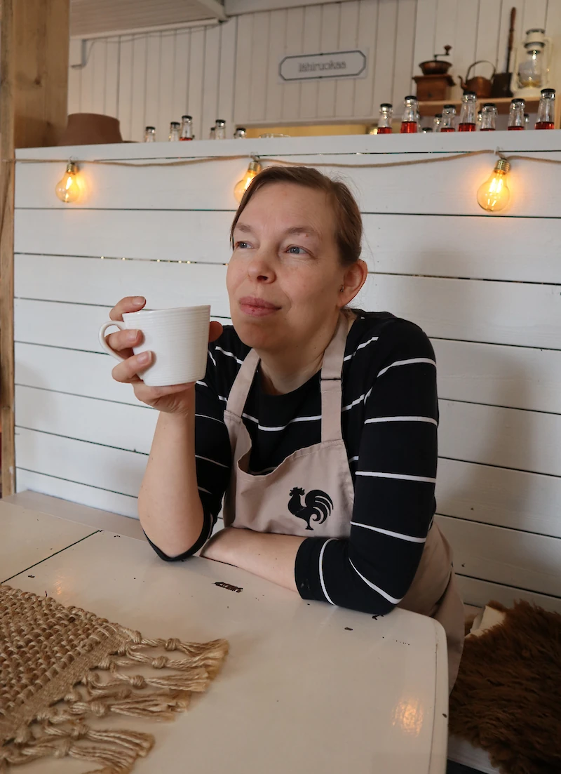 Anu Korhonen viettämässä kahvihetkeä työpaikallaan Iitin Maatilatorilla.