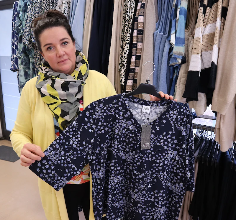 Anna Koski esittelee kukallista puseroa, jossa on riittävästi hihaa. Näillä piirteillä varustetut puserot ovat asiakkaiden suosiossa.