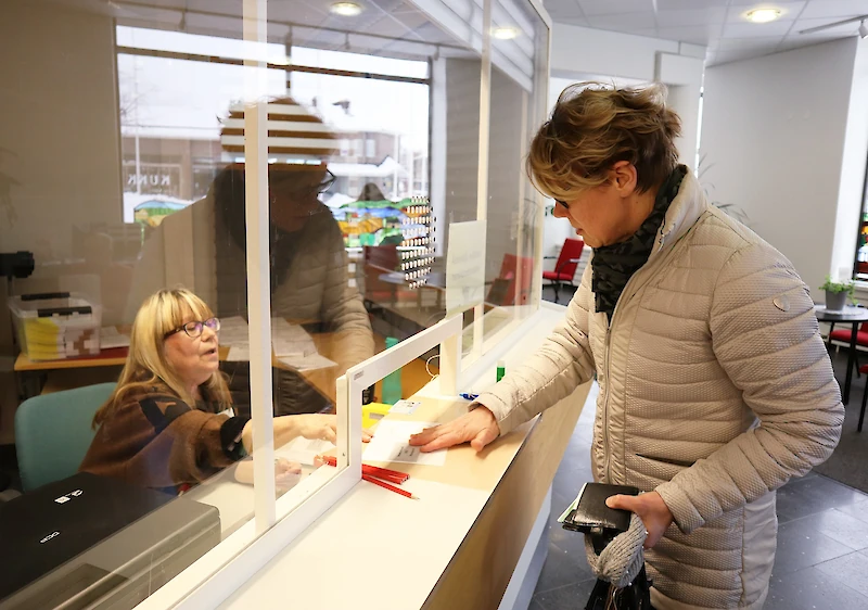 Vaalitoimitsija Iina Helander palveli ennakkoäänestämään tullutta Niina Hömppiä Iitin kunnantalolla tiistaina. (Kuva: Minna Tervo.)