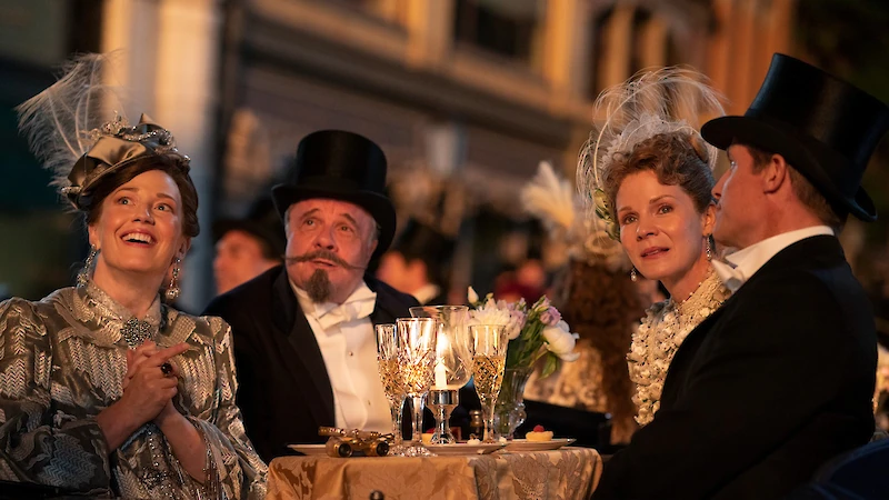 Tässä seurataan julkista näytöstä, jossa sähkövalot sytytetään kokonaiseen kerrostaloon. Näytöksessä on mukana myös hehkulampun keksijä Thomas Edison. (Kuva: HBO.)
